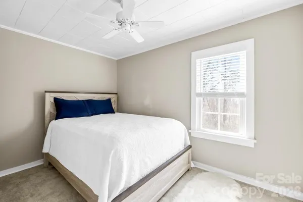 a large bed sitting in a bedroom next to a window