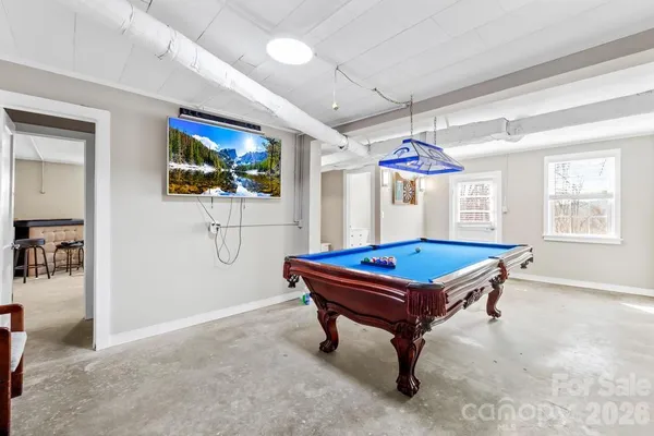 a room with pool table and windows