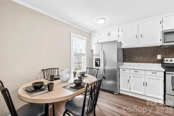 a kitchen with white cabinets and stainless steel appliances