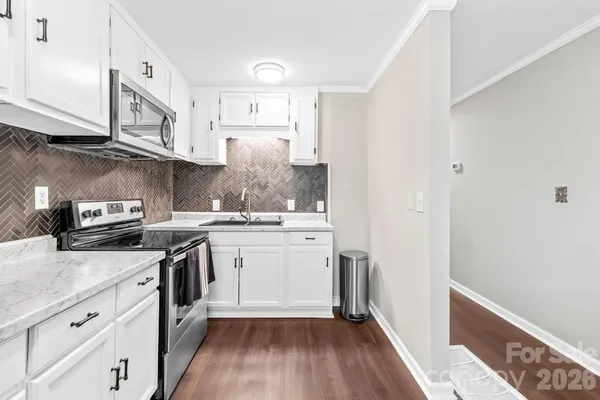 a kitchen with a sink a stove and cabinets