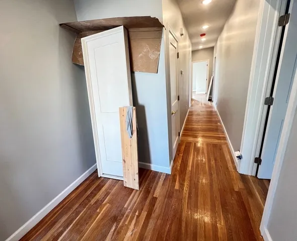 a view of a hallway with wooden floor and stairs