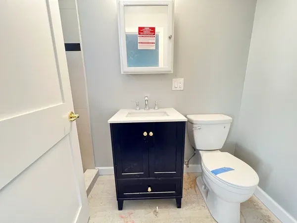a bathroom with a toilet a sink and a mirror