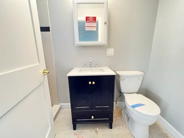 a bathroom with a toilet a sink and a mirror