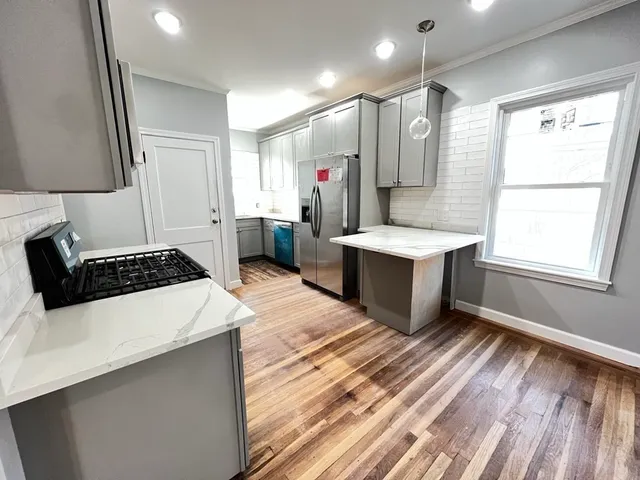 a kitchen with stainless steel appliances a sink stove and refrigerator