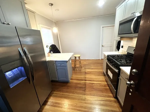 a kitchen with stainless steel appliances granite countertop a refrigerator a stove and a sink