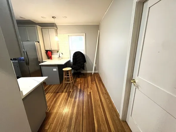 a living room with a sink and wooden floor