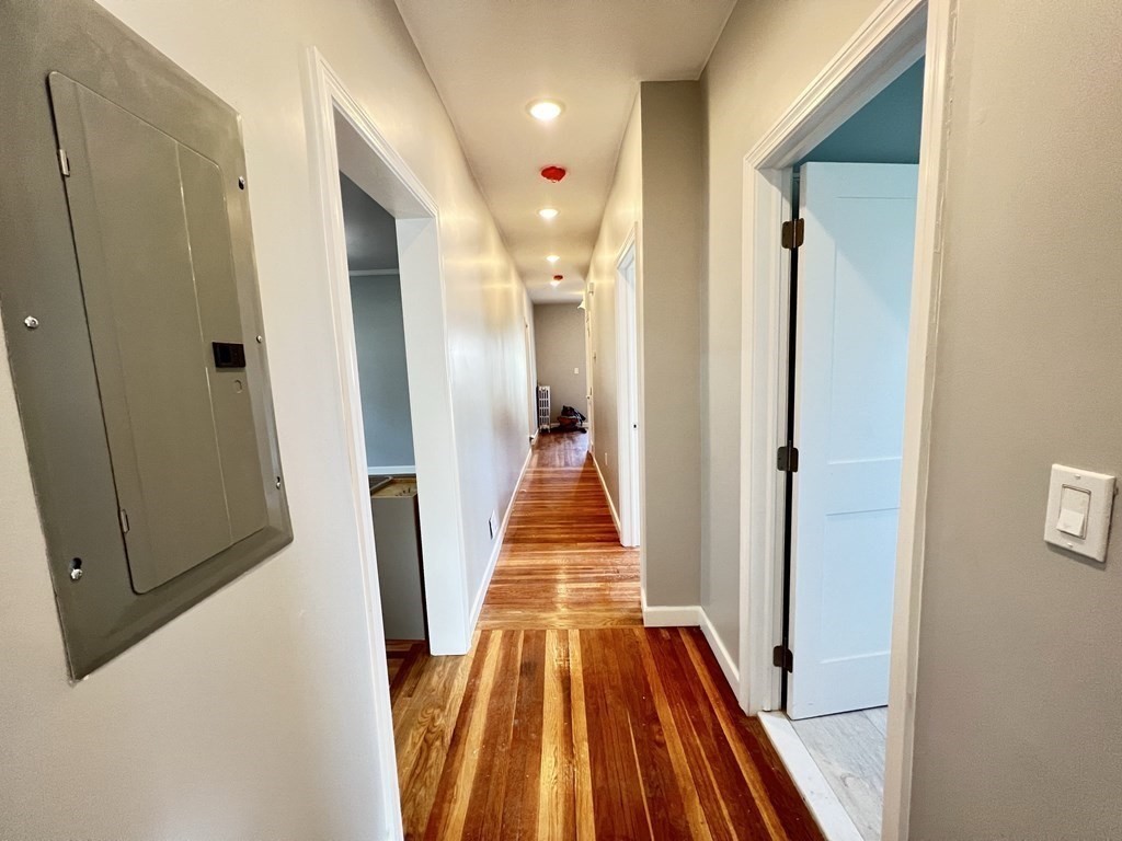 25 Teragram Street, Unit 1 Boston, MA 02128 - Photo 8 of 21 a view of a hallway with wooden floor and a bathroom