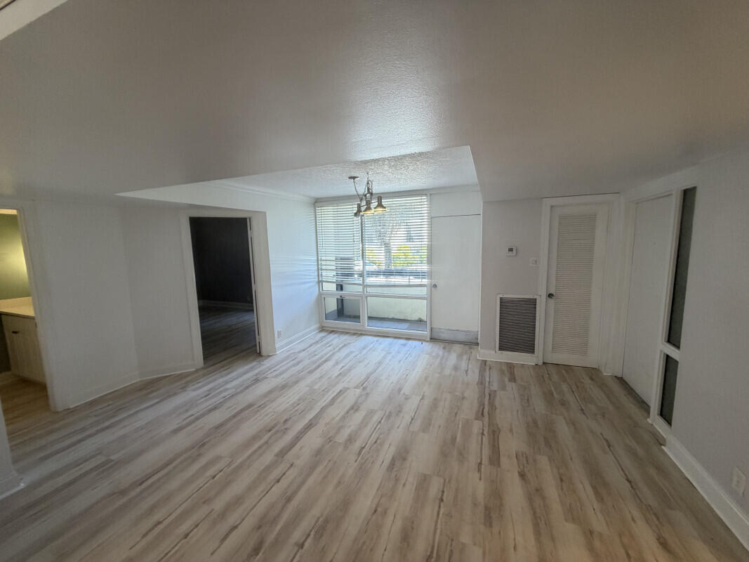 1401 South Federal Highway, Unit 102 Boca Raton, FL 33432 - Photo 21 of 38 an empty room with wooden floor and a kitchen