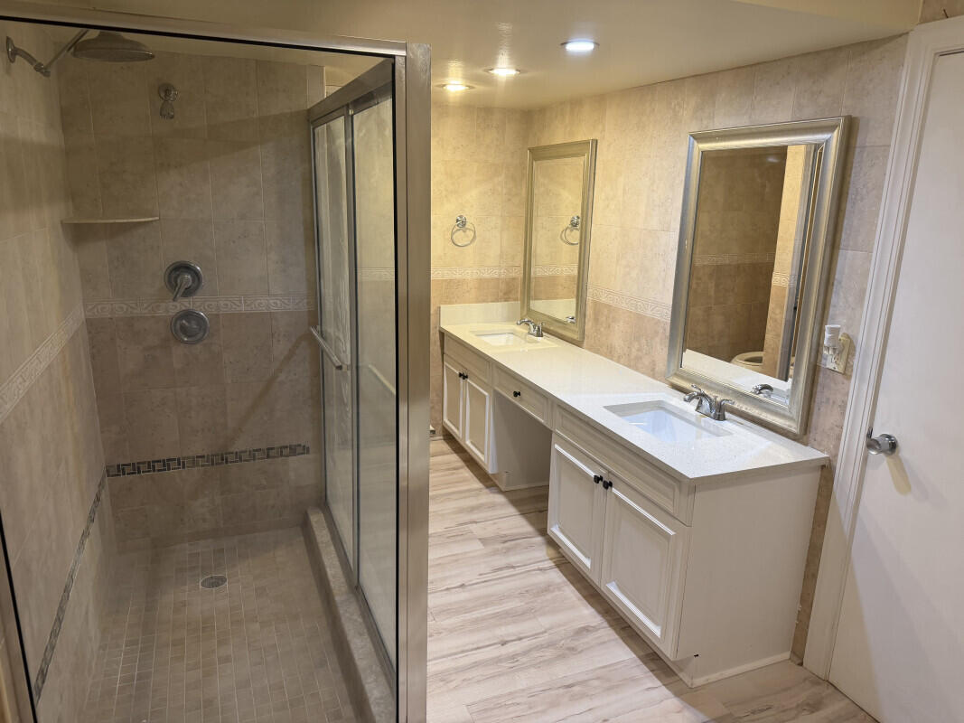 1401 South Federal Highway, Unit 102 Boca Raton, FL 33432 - Photo 29 of 38 a bathroom with a double vanity sink a toilet and shower