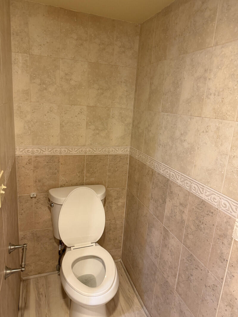 1401 South Federal Highway, Unit 102 Boca Raton, FL 33432 - Photo 33 of 38 a white toilet sitting in a bathroom and a sink