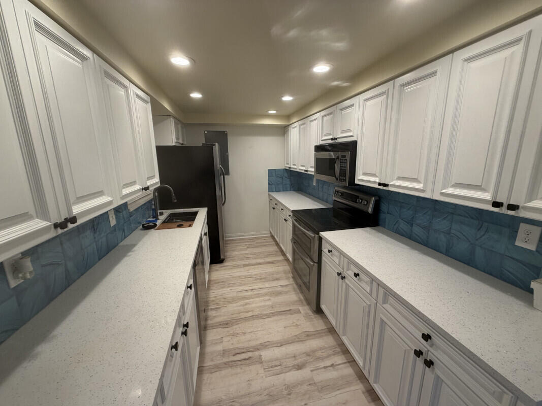 1401 South Federal Highway, Unit 102 Boca Raton, FL 33432 - Photo 4 of 38 a kitchen with a sink a counter top space a refrigerator and cabinets