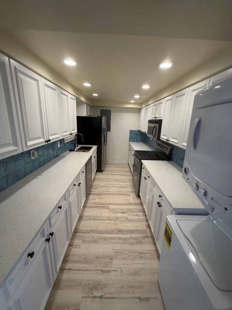 1401 South Federal Highway, Unit 102 Boca Raton, FL 33432 - Photo 9 of 38 a large white kitchen with wooden cabinets and a sink