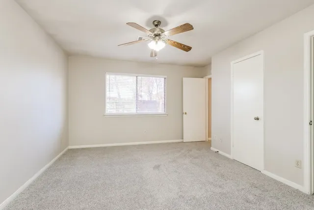 a view of an empty room with a ceiling fan