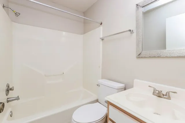a white toilet sitting next to a bath tub