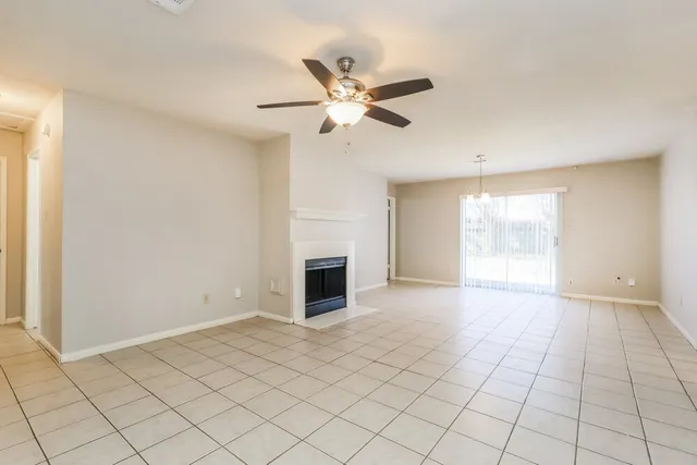 a view of an empty room with a ceiling fan and a window