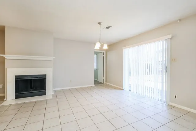 a view of an empty room with window and fire place