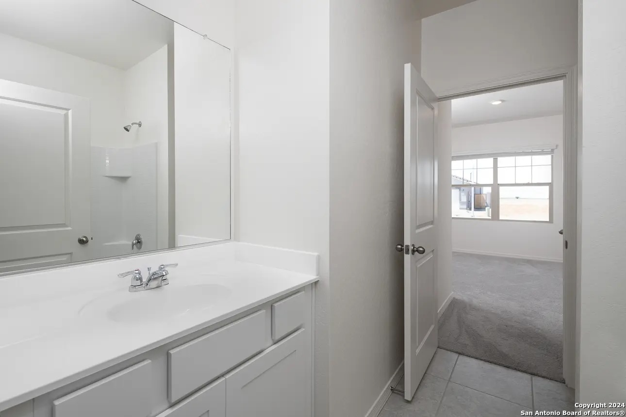 10523 Lesser Snow Adkins, TX 78101 - Photo 6 of 12 a bathroom with a sink and a mirror