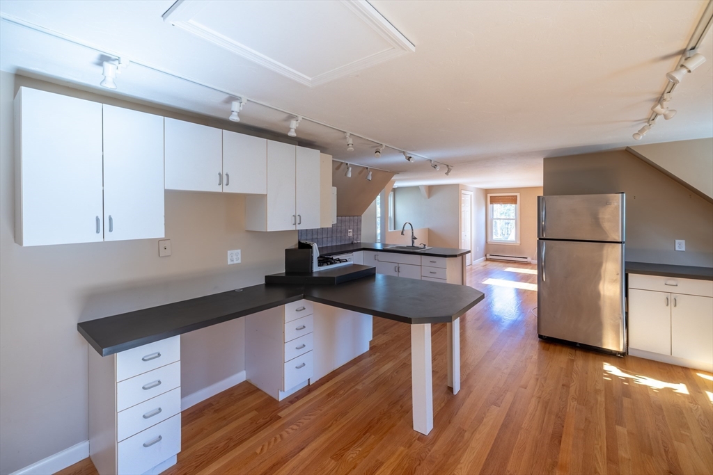 956 Bay Road, Unit 3 Hamilton, MA 01982 - Photo 8 of 30 a kitchen with stainless steel appliances granite countertop a sink refrigerator and cabinets