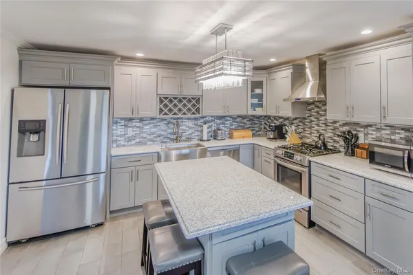 a kitchen with a sink a stove a refrigerator and white cabinets