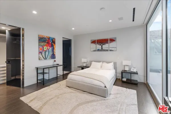 a bedroom with a balcony a large bed and a potted plant