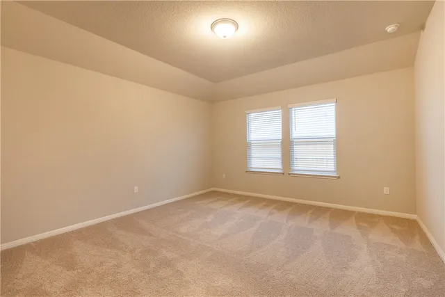 a view of a big room with wooden floor and windows