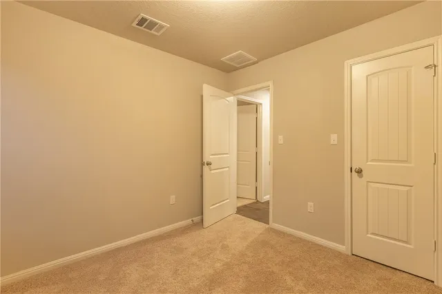 an empty room with wooden floor and a bathroom