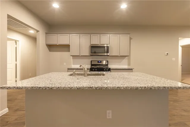 a kitchen with a sink stove and microwave