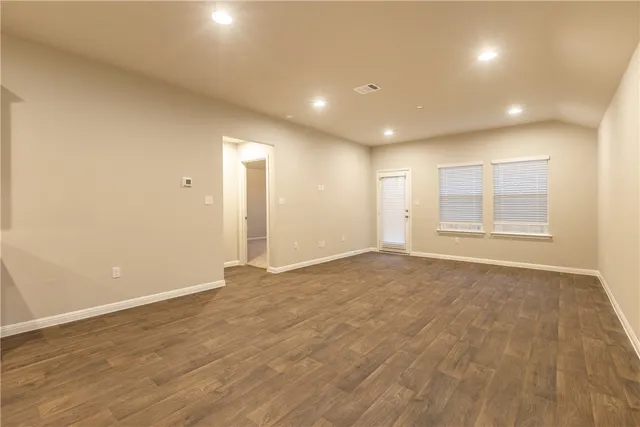 a kitchen with a sink wooden floor and a refrigerator