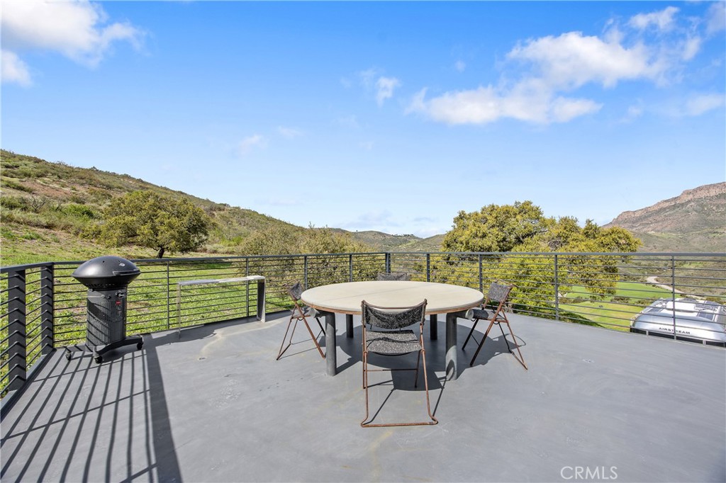 10120 Yerba Buena Road Malibu, CA 90265 - Photo 11 of 40 a view of a terrace with a table and chairs