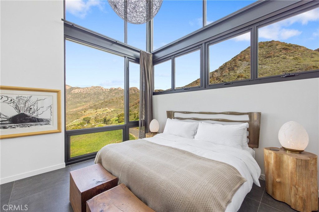 10120 Yerba Buena Road Malibu, CA 90265 - Photo 14 of 40 a bedroom with a bed and a large window with the view of balcony