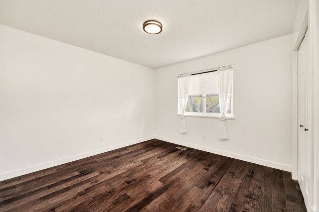 365 South Center Street Fielding, UT 84311 - Photo 16 of 41 Unfurnished bedroom featuring dark wood-style floors and a closet