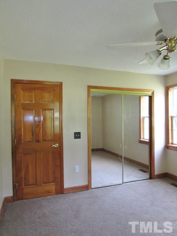 558 Robert Gentry Road Timberlake, NC 27583 - Photo 13 of 25 Bedroom 2 shows the solid wood doors that are throughout this home, new carpet, and mirrored closet door