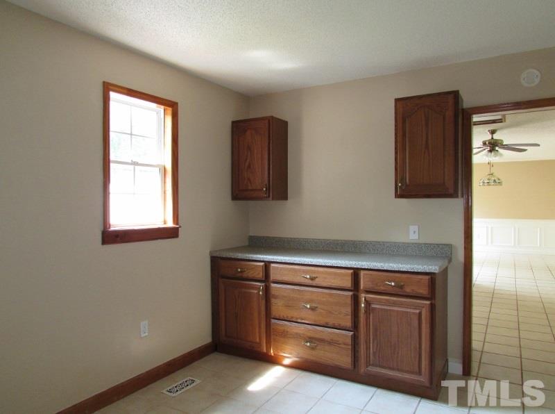 558 Robert Gentry Road Timberlake, NC 27583 - Photo 17 of 25 Utility room has washer/dryer hookups, cabinet storage and new counter top for folding cloths. Located between the garage and kitchen.