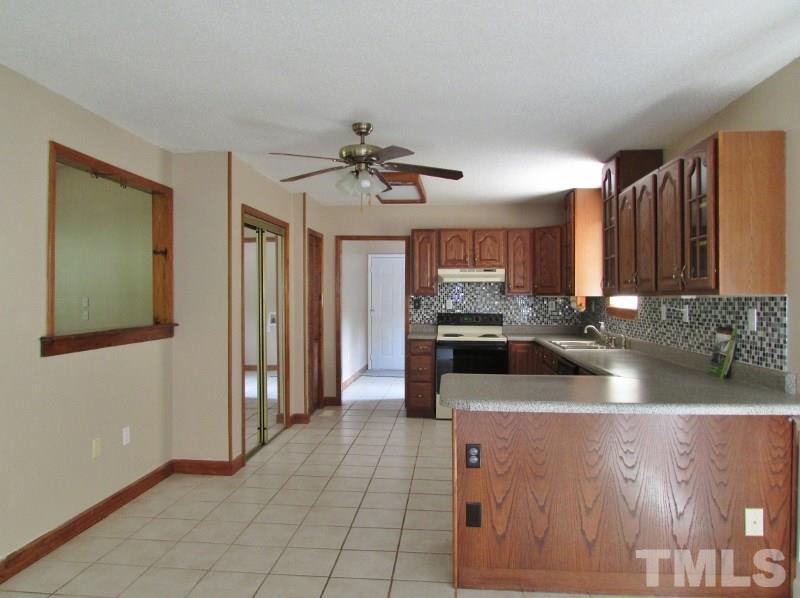 558 Robert Gentry Road Timberlake, NC 27583 - Photo 6 of 25 Kitchen has new spill guard counter tops, tile back splash, new double sink and faucet. Pantry with mirror accent doors, broom closet, lots of cabinets and storage space