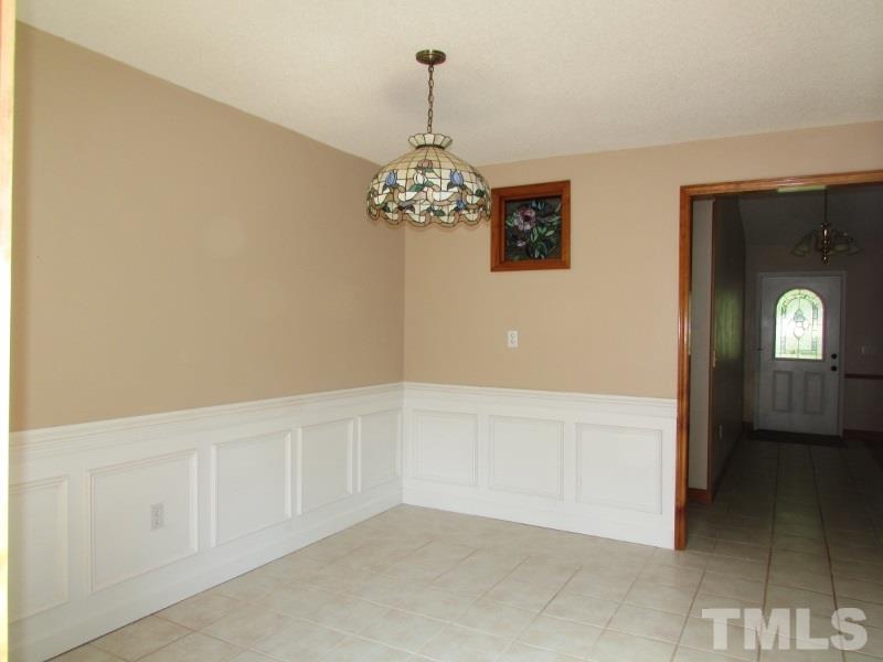 558 Robert Gentry Road Timberlake, NC 27583 - Photo 8 of 25 Dining is open to kitchen, tile floor, new wainscot and sliding glass door to deck.