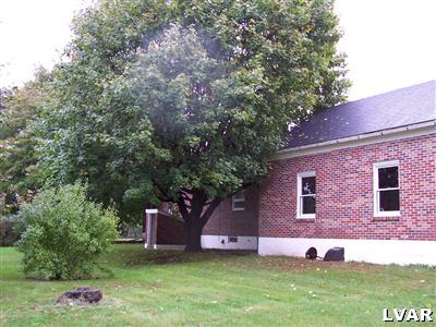 529 Jacobsburg Road Nazareth, PA 18064 - Photo 4 of 9 a view of a brick house with a yard and large tree