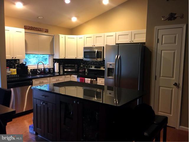 8107 Hog Neck Road Pasadena, MD 21122 - Photo 6 of 27 a kitchen with granite countertop a refrigerator and a sink