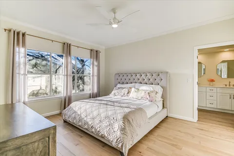 a bedroom with a large bed a chandelier and a window