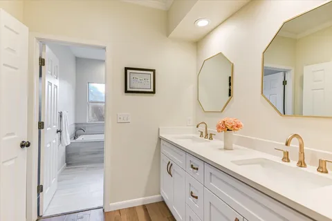 a bathroom with a double vanity sink mirror and shower