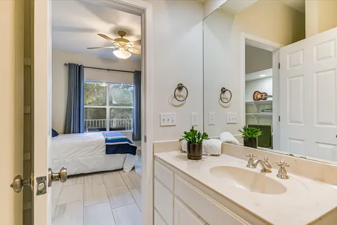 a en suite bathroom with a granite countertop sink and a mirror