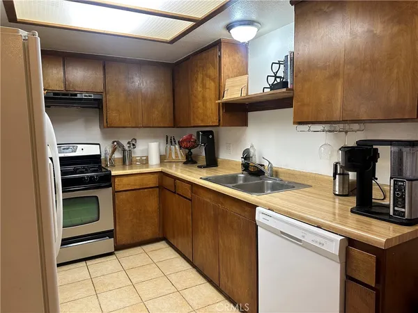 a kitchen with stainless steel appliances granite countertop a refrigerator a stove and a sink