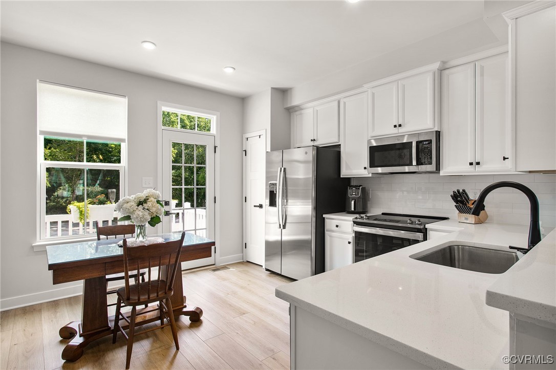1321 Ewing Pk Loop Midlothian, VA 23113 - Photo 15 of 30 a kitchen with a sink a stove a refrigerator cabinets and dining table