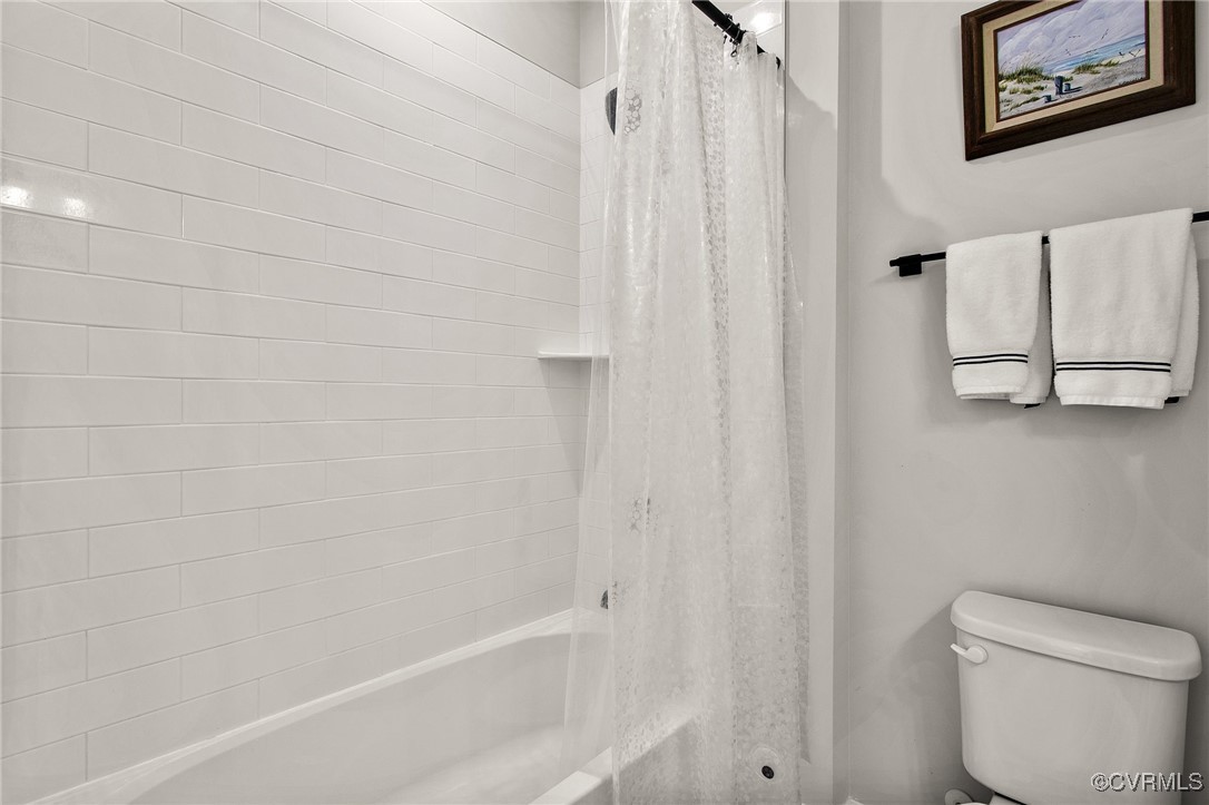 1321 Ewing Pk Loop Midlothian, VA 23113 - Photo 25 of 30 a white bath tub sitting next to a white toilet and curtain