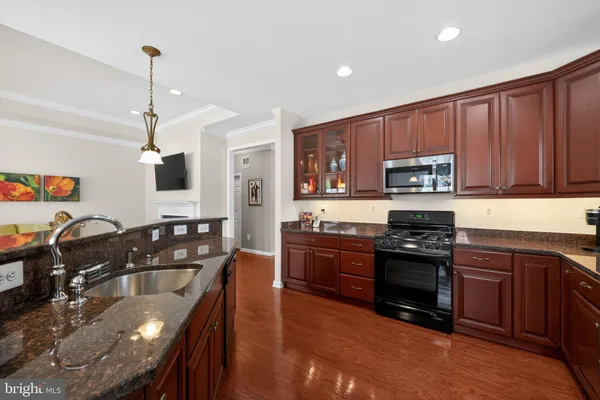 a kitchen with granite countertop a stove sink and microwave