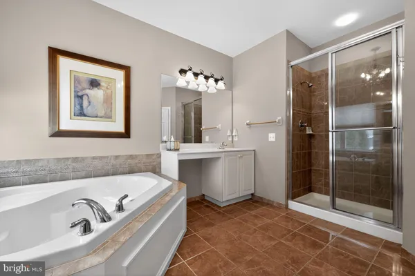 a bathroom with a tub a sink and mirror