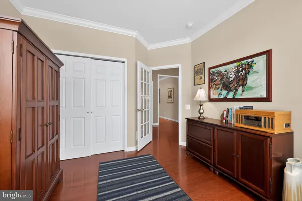 a view of a bedroom with workspace and wooden floor