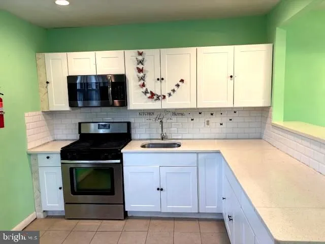 a kitchen with stainless steel appliances a stove sink and microwave