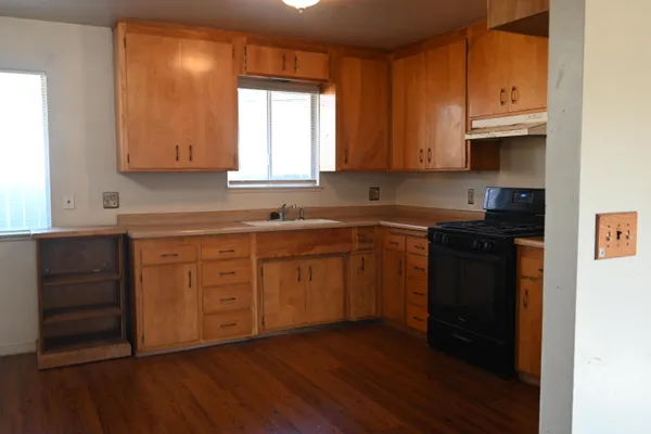 a kitchen with a sink a window and cabinets
