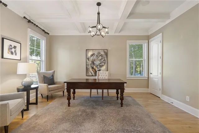 a dining room with wooden floor a chandelier a glass table and chairs