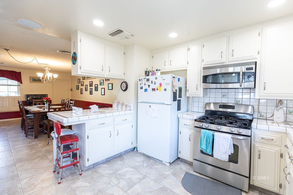 737 Scott Circle Ridgecrest, CA 93555 - Photo 15 of 49 a kitchen with white cabinets and appliances